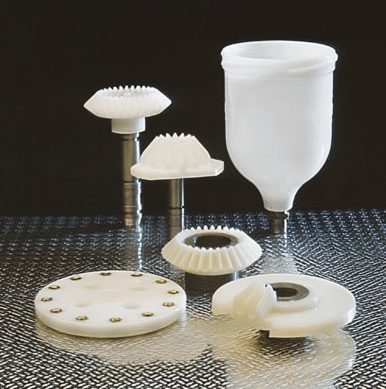 Selection of plastic parts with overmoulded metal fittings, standing on a silver/black sheet